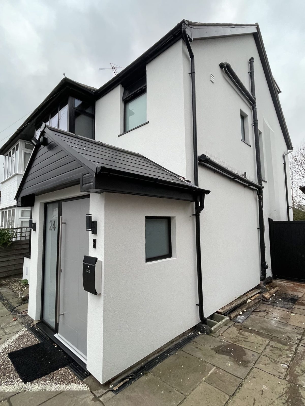 Rendered porch detail with anthracite cladding and grey front door