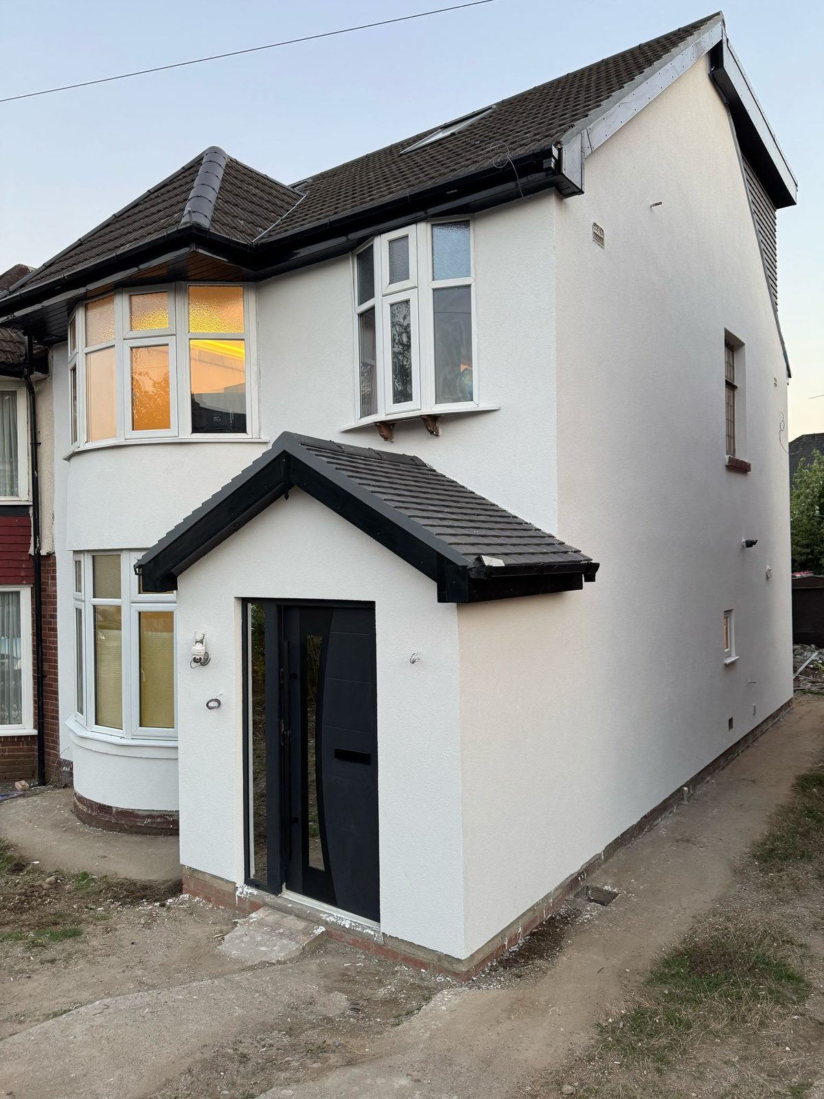 Finished silicone render on a semi-detached house at dusk